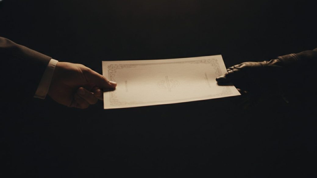 A single share certificate document passing hand to hand, warm dramatic lighting, shallow depth of field, clean dark background, high contrast, no text or watermark