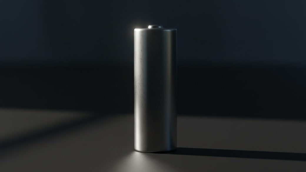 A single shiny cylindrical lithium battery cell standing upright on a clean dark surface, dramatic side lighting, high contrast, no text