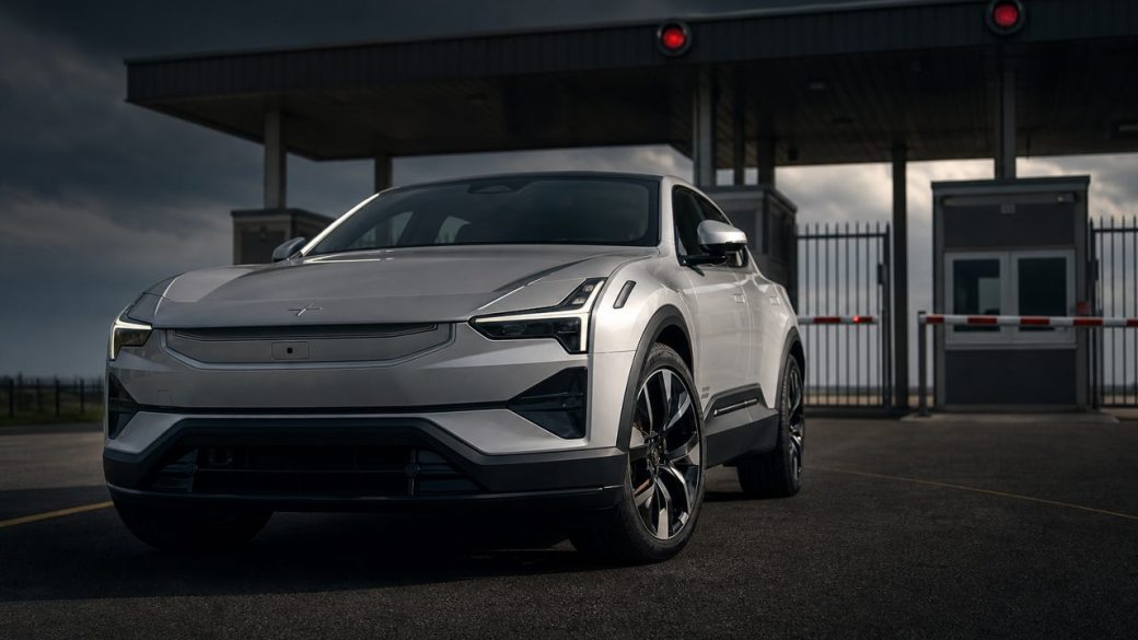 A sleek Polestar electric car parked at a closed US border gate, dramatic low-angle lighting, clean dark background, high contrast, no text
