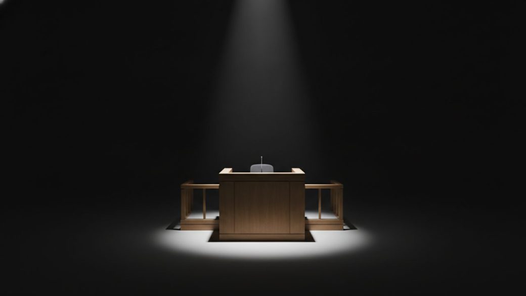 A single empty courtroom witness stand under a dramatic shaft of light, clean dark background, high contrast, no text or logos